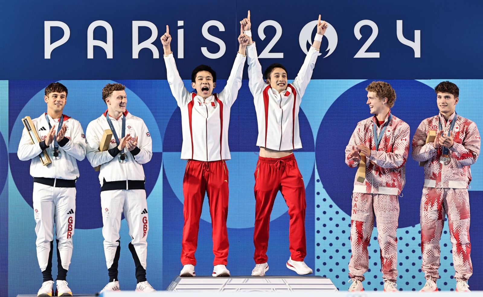 SAINT-DENIS, FRANCE - JULY 29: Gold medalists Lian Junjie and Yang Hao (C) of Team China celebrate on the podium alongside silver medalists Thomas Daley and Noah Williams (L) of Team Great Britain and bronze medalists Rylan Wiens and Nathan Zsombor-Murray of Team Canada during the medal ceremony after the Diving - Men's Synchronised 10m Platform Final on day three of the Paris 2024 Olympic Games at Aquatics Centre on July 29, 2024 in Saint-Denis, France. (Photo by Bai Yu/CHINASPORTS/VCG via Getty Images)