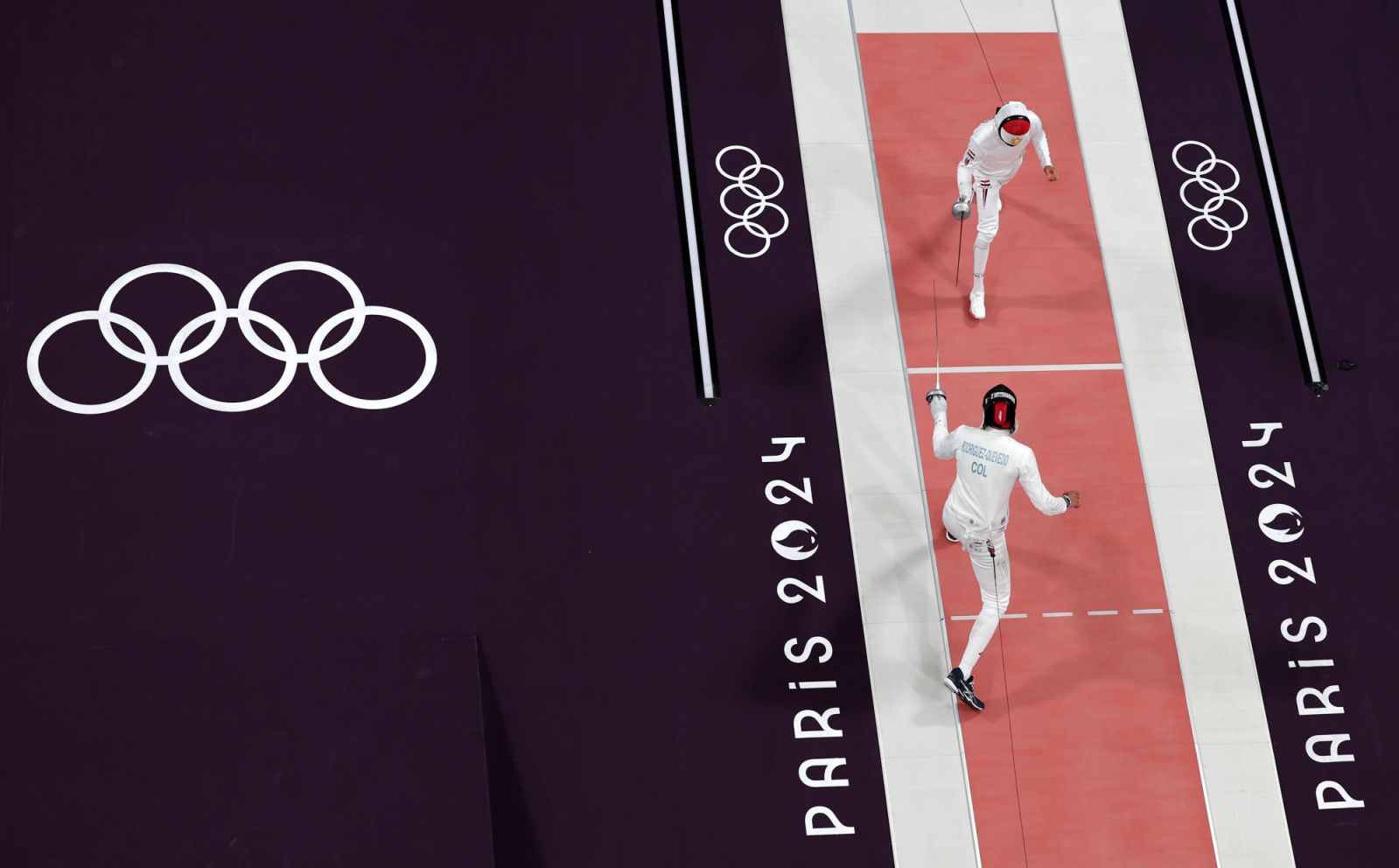 PARIS, FRANCE - JULY 28: (EDITORS NOTE: Image was captured using a robotic camera positioned above the field of play) Mohamed Elsayed of Team Egypt (top) and John Edison Rodriguez of Team Colombia (bottom) compete in the Fencing Men's Epee Individual Table of 32 on day two of the Olympic Games Paris 2024 at Grand Palais on July 28, 2024 in Paris, France. (Photo by Rob Carr/Getty Images)