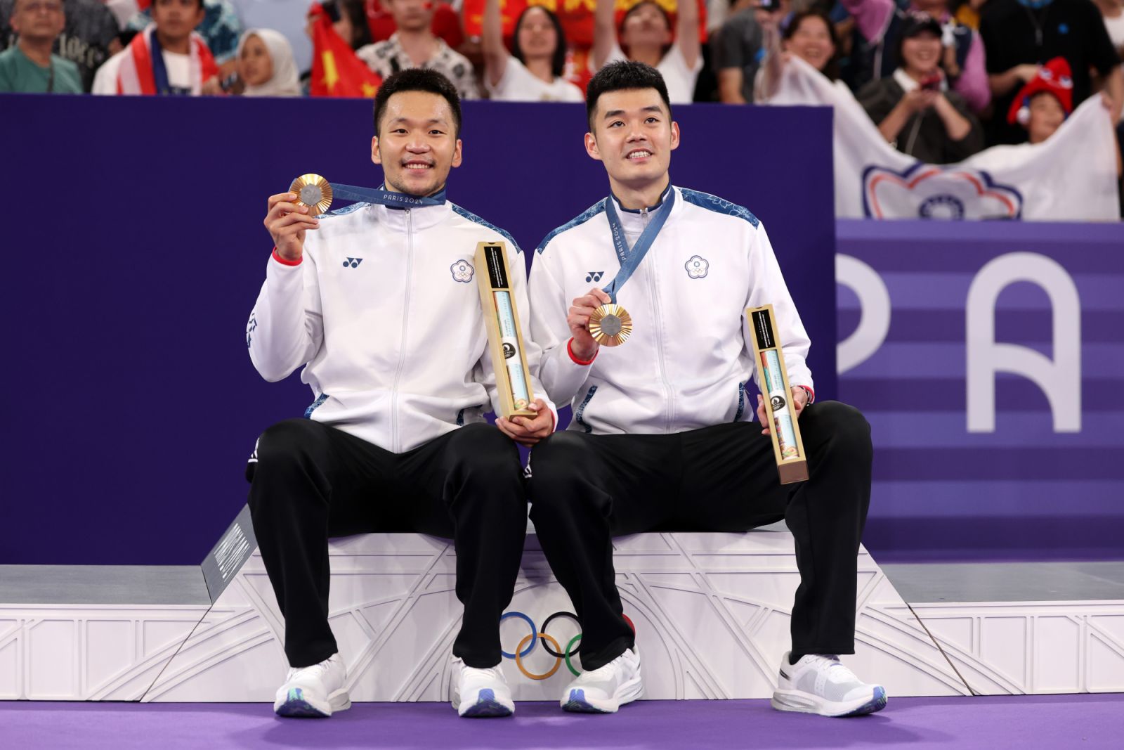 PARIS, FRANCE - AUGUST 04: Gold medallists Yang Lee and Chi-Lin Wang of Team Chinese Taipei pose on the podium during the Badminton Men's Doubles medal ceremony after the Badminton Men's Doubles matches on day nine of the Olympic Games Paris 2024 at Porte de La Chapelle Arena on August 04, 2024 in Paris, France. (Photo by Michael Reaves/Getty Images)