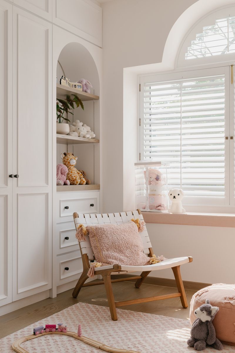 Arcged carpentry and window add softness to bedroom