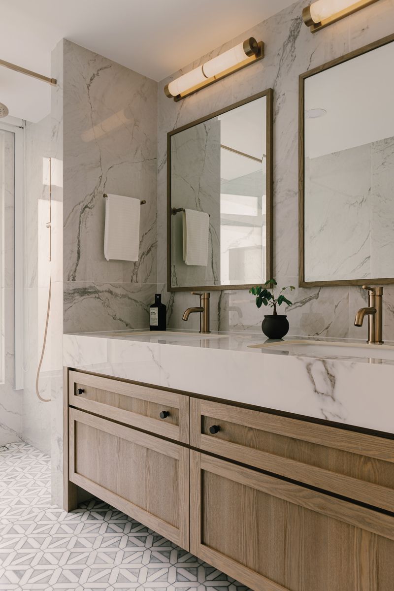 The master bathroom features a double vanity adorned with burnished metal hardware