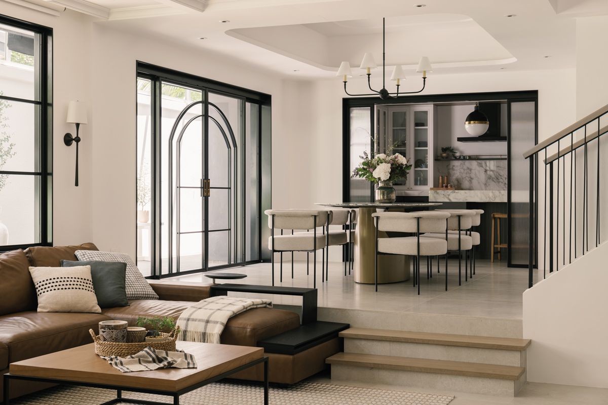 The difference in elevation between the dining and living areas demarcates the two zones while keeping the overall interior open