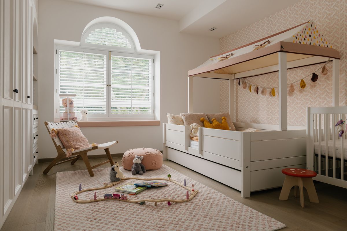 The daughters’ delightful bedroom features subtle accents of baby pink