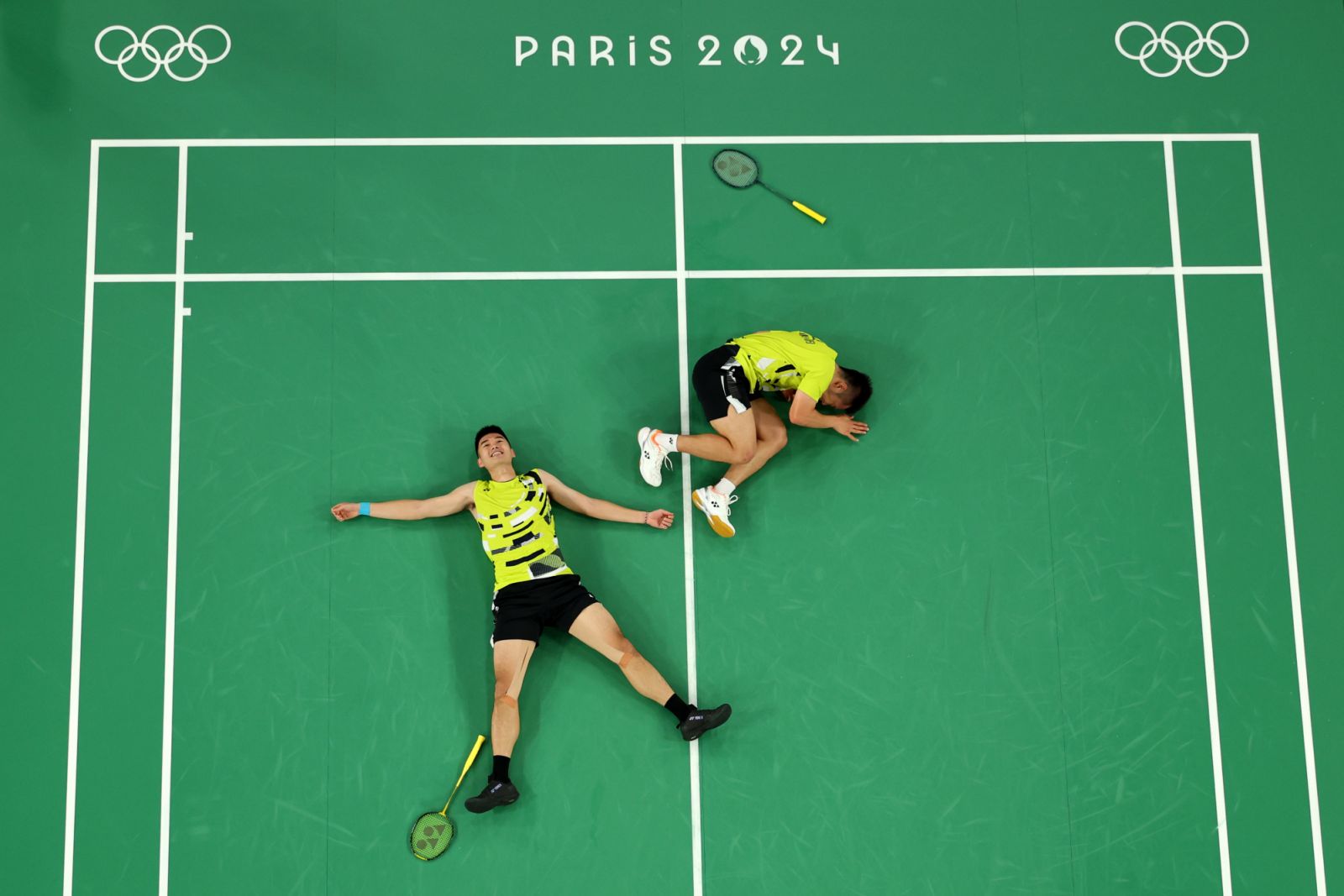 PARIS, FRANCE - AUGUST 04: (EDITORS NOTE: Image was captured using a robotic camera positioned above the field of play.) Yang Lee and Chi-Lin Wang of Team Chinese Taipei celebrate victory during the Badminton Men's Doubles Gold Medal match against Chang Wang and Wei Keng Liang of Team People’s Republic of China on day nine of the Olympic Games Paris 2024 at Porte de La Chapelle Arena on August 04, 2024 in Paris, France. (Photo by Rob Carr/Getty Images)