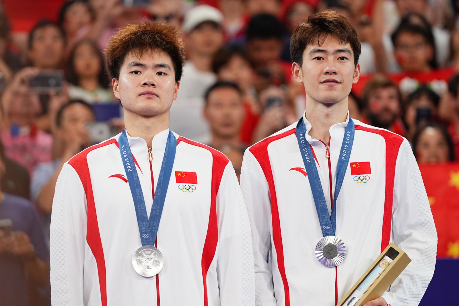PARIS, FRANCE - AUGUST 04: Sliver medalists Wang Chang and Liang Weikeng of Team China pose with medals during the award ceremony for the Badminton - Men's Doubles Gold Medal match on day nine of the Paris 2024 Olympic Games at Porte de La Chapelle Arena on August 4, 2024 in Paris, France. (Photo by Zhao Wenyu/China News Service/VCG via Getty Images)