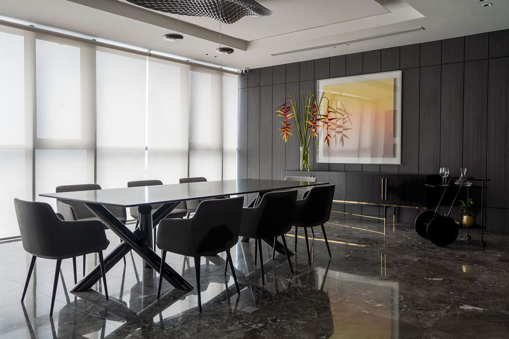 The handsome dining area features artwork and a wavy modern Artemide light by Ross Lovegrove