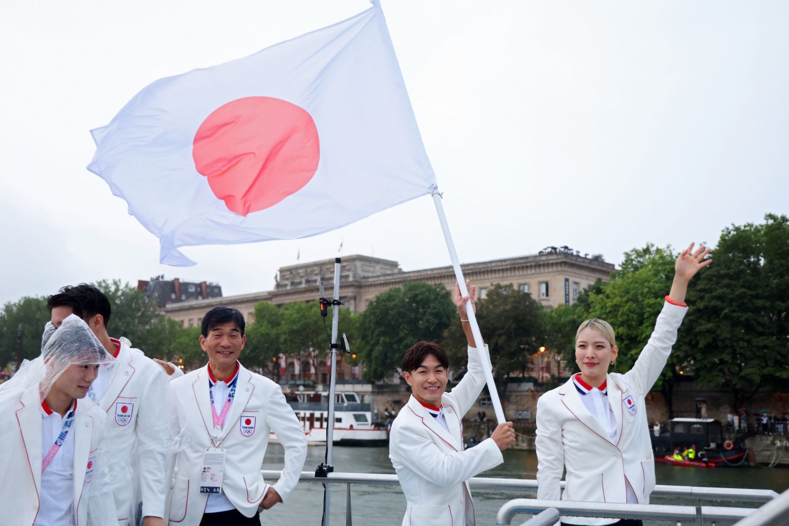 PARIS, FRANCE - JULY 26: Misaki Emura and Shigekix, Flagbearers of Team Japan, are seen on a boat waving their flag along the River Seine during the opening ceremony of the Olympic Games Paris 2024 on July 26, 2024 in Paris, France. (Photo by Michael Reaves/Getty Images)