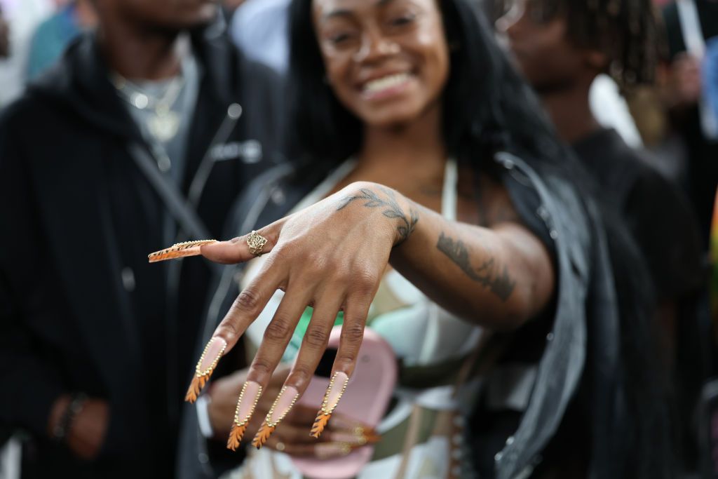 PARIS, FRANCE - AUGUST 10: Sha'Carri Richardson shows off her nails during the Men's Gold Medal Game on day fifteen of the Olympic Games Paris 2024 at Bercy Arena on August 10, 2024 in Paris, France. (Photo by Amin Mohammad Jamali/Getty Images)