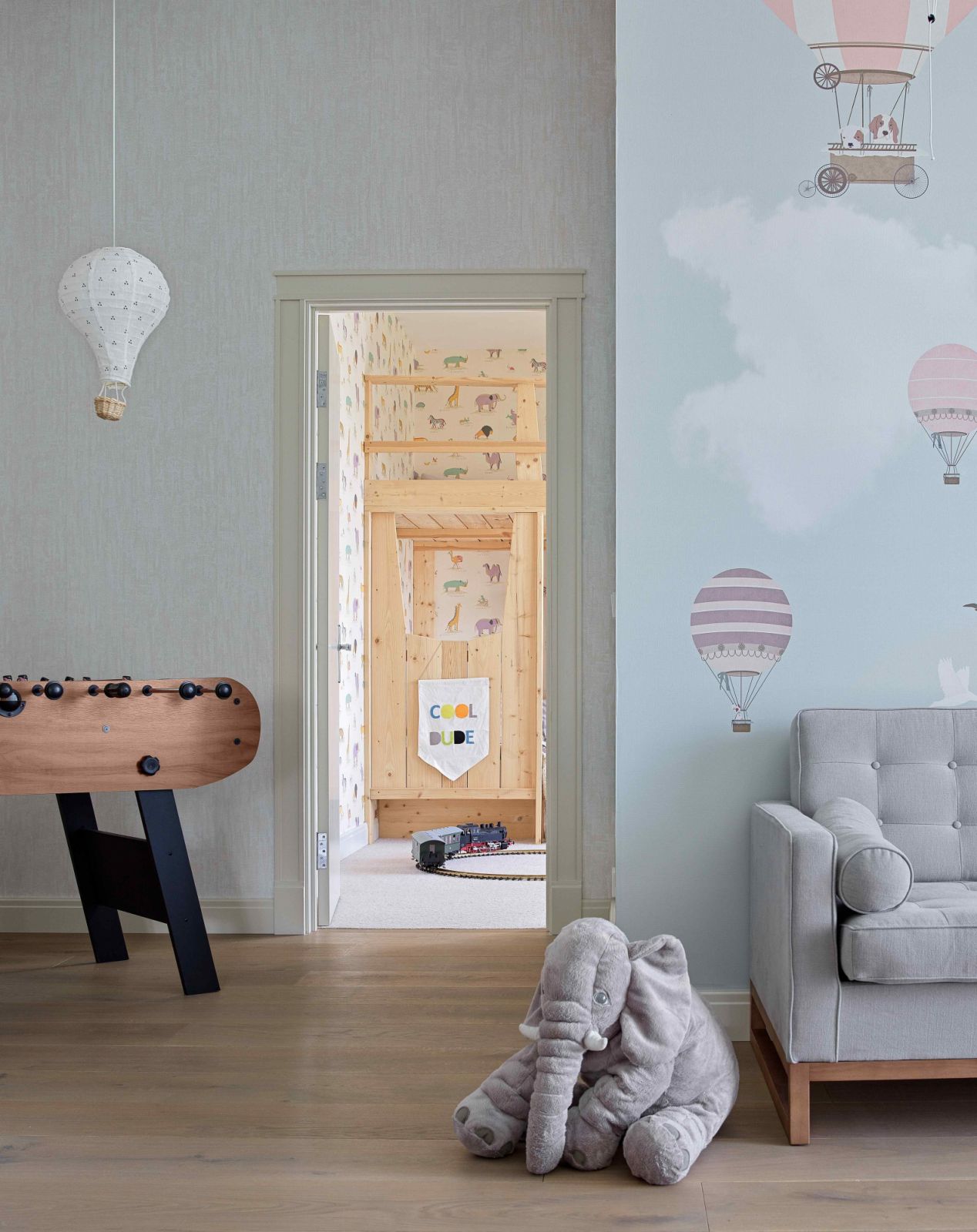 The powder blue wallpaper and wooden flooring exude whimsical calm