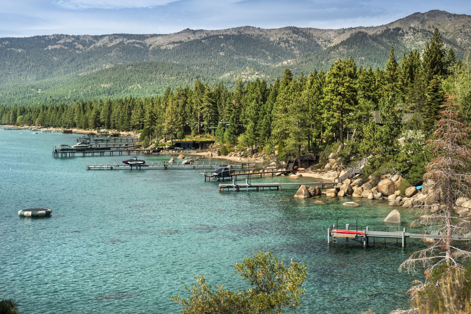 Scenic nature view of boats docked over the waters of Lake Tahoe from the rocky boulders on shore in summer (Photo: Getty Images)