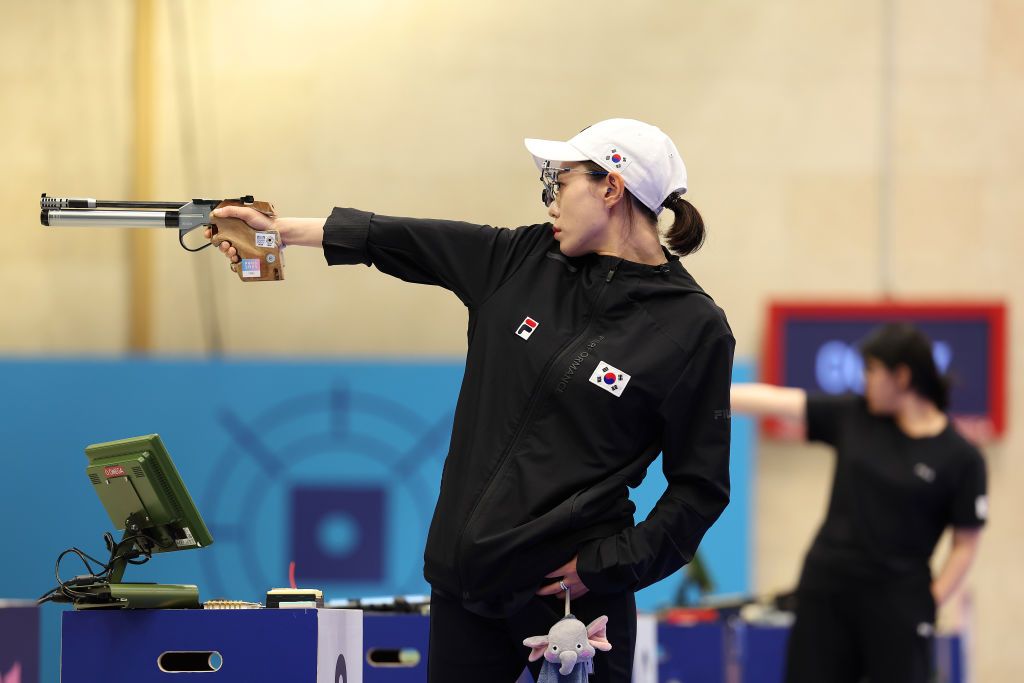 Kim Yeji of team Korea shoots during the women's 10m air pistol final at the Olympics, her daughter’s soft toy hanging by her pocket (Photo: Getty Images)
