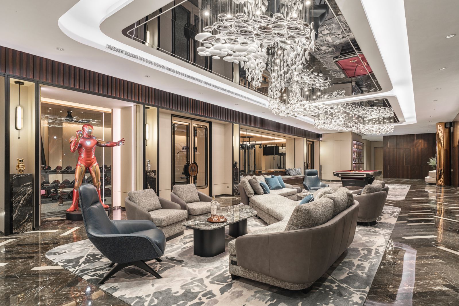 The elongated entertainment room is demarcated into smaller zones with a zig-zagging sofa configuration