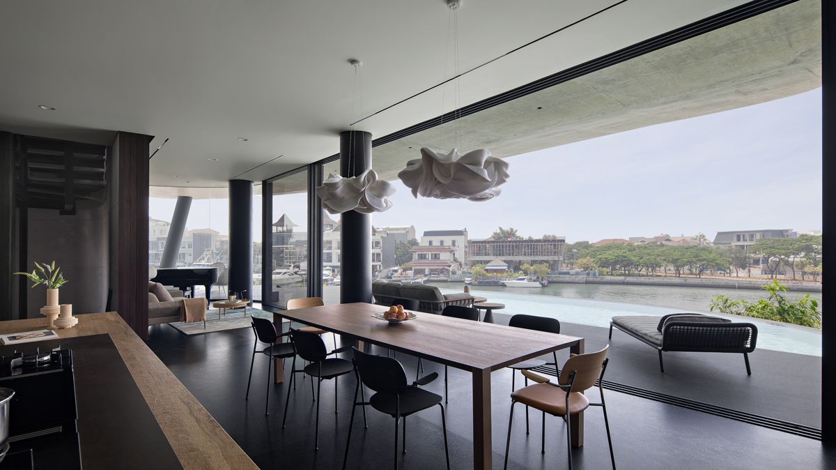 The kitchen, dining and living areas open up to the balcony, pool and sweeping views of the canal