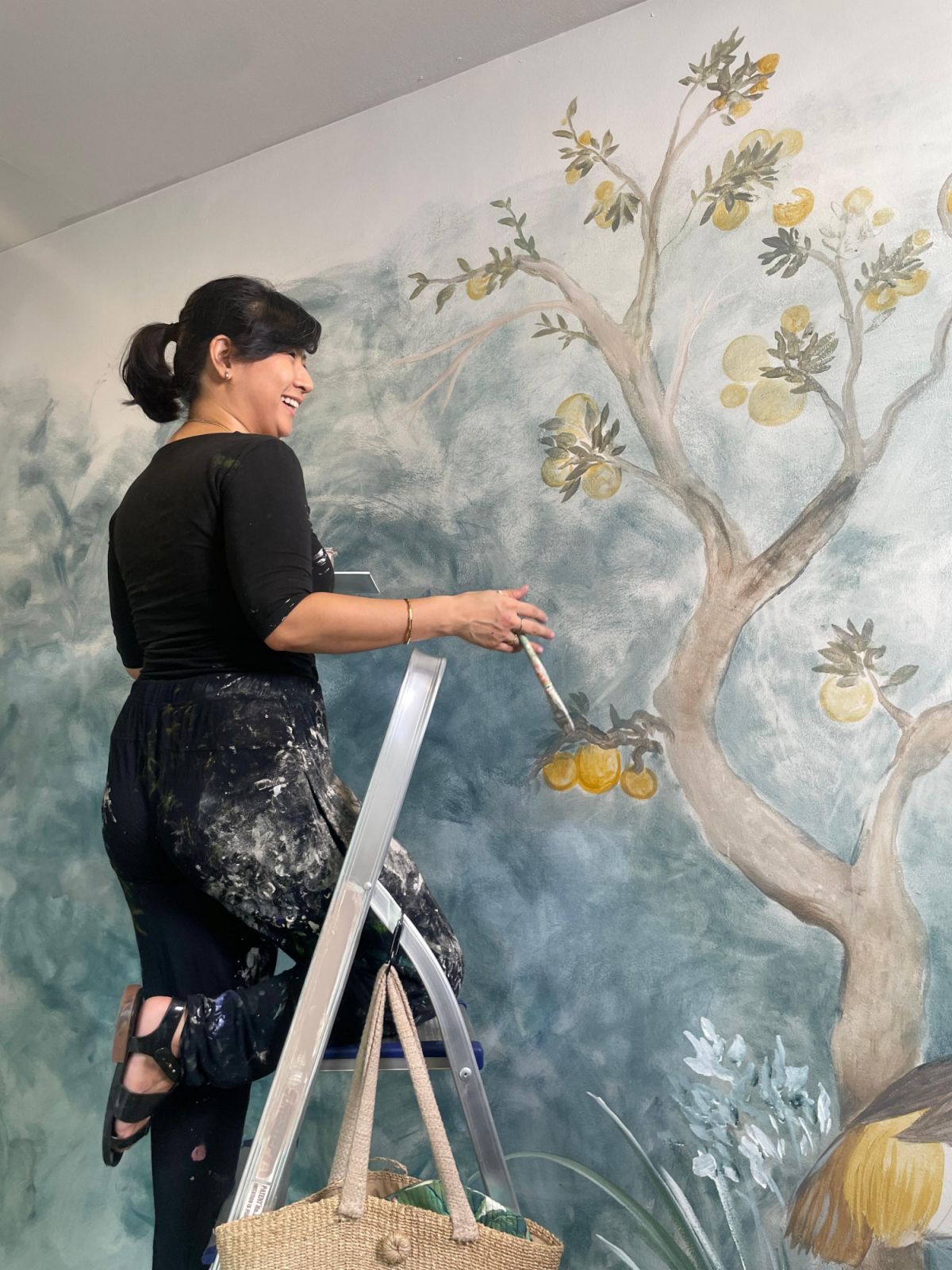 Tara Soriano working on a home mural