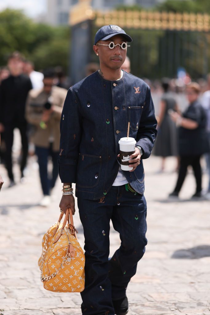 PARIS, FRANCE - JUNE 23: Pharrell Williams is seen wearing a Louis Vuitton denim set, Louis Vuitton cup, Tiffany & Co diamond shades and Louis Vuitton yellow croco leather Speedy bag outside Dior Homme during the Menswear Spring Summer 2024 as part of Paris Fashion Week on June 23, 2023 in Paris, France. (Photo by Jeremy Moeller/Getty Images)