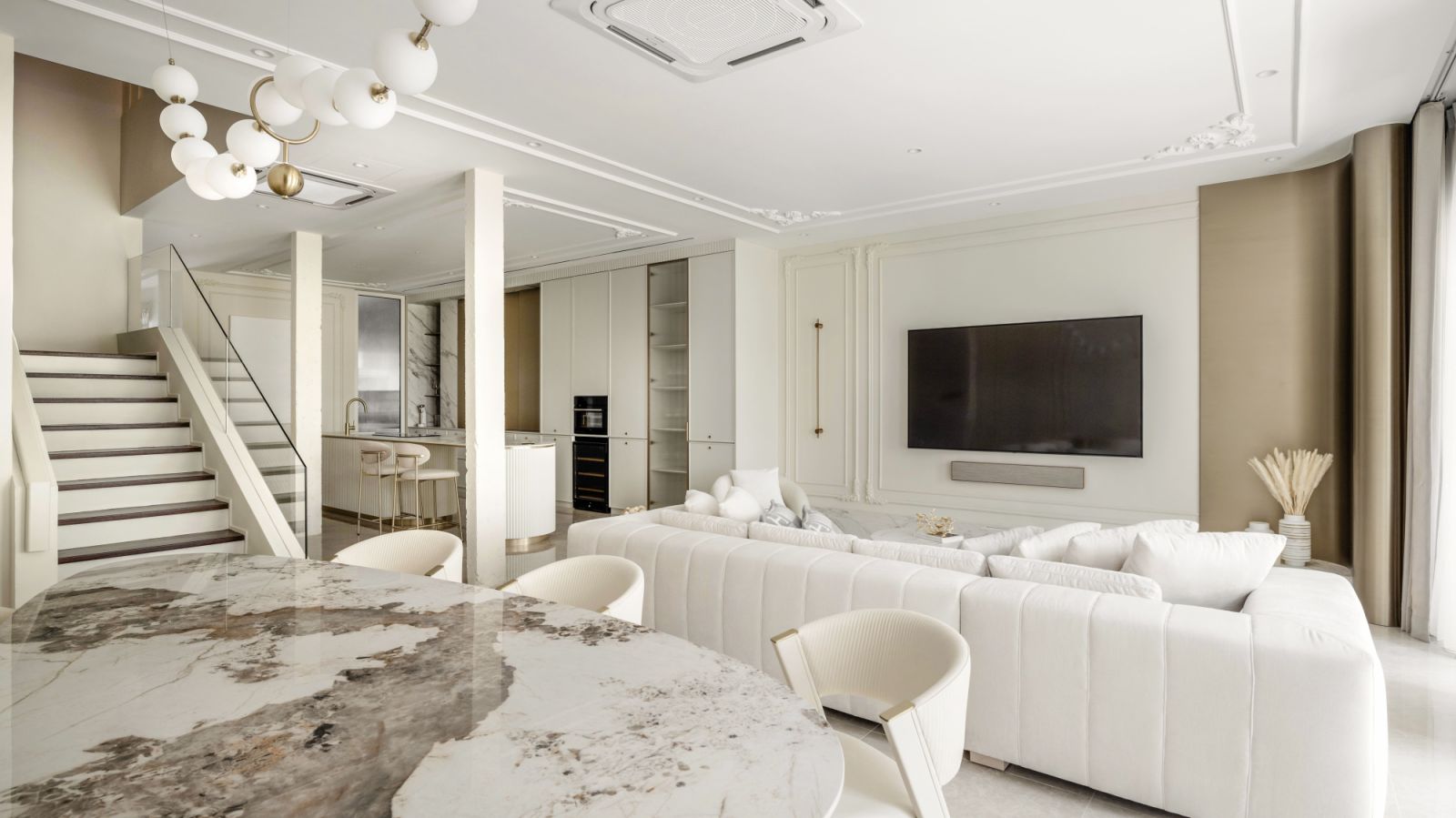The living, dining areas and kitchen are one combined space, allowing for easy interaction with guests.