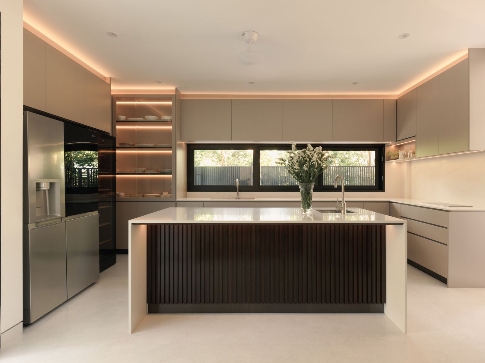 Soft lighting enriches the kitchen’s linear design