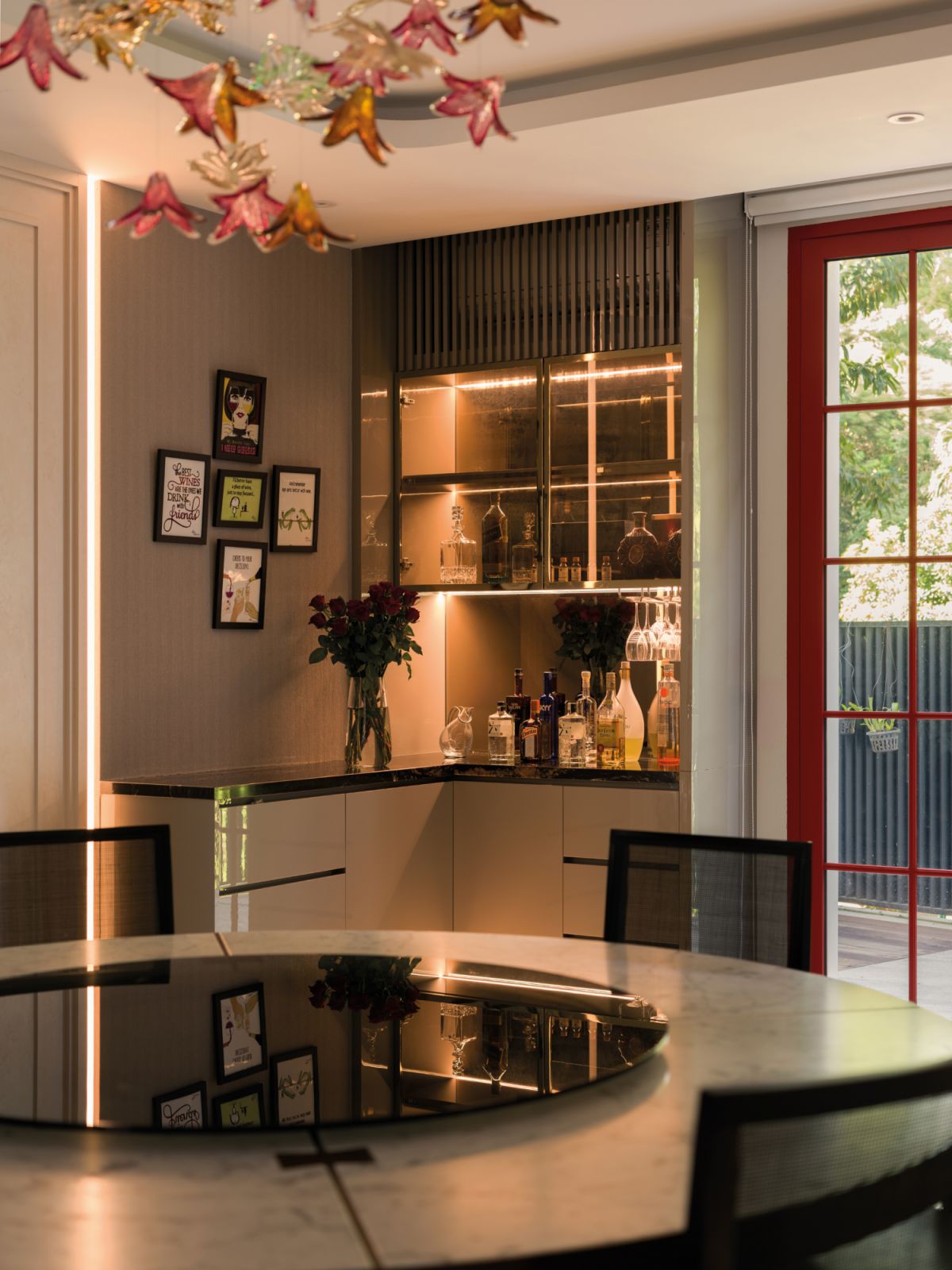 A snug corner is turned into a functional bar area, with the French doors next to it painted a striking red hue