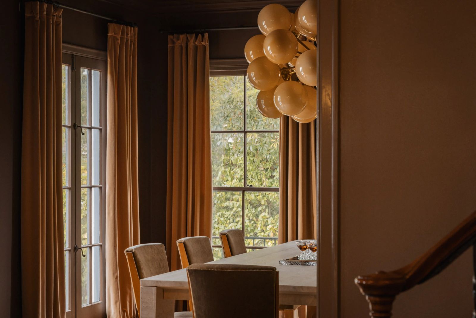 The jewel-toned palette juxtaposes the greenery outside