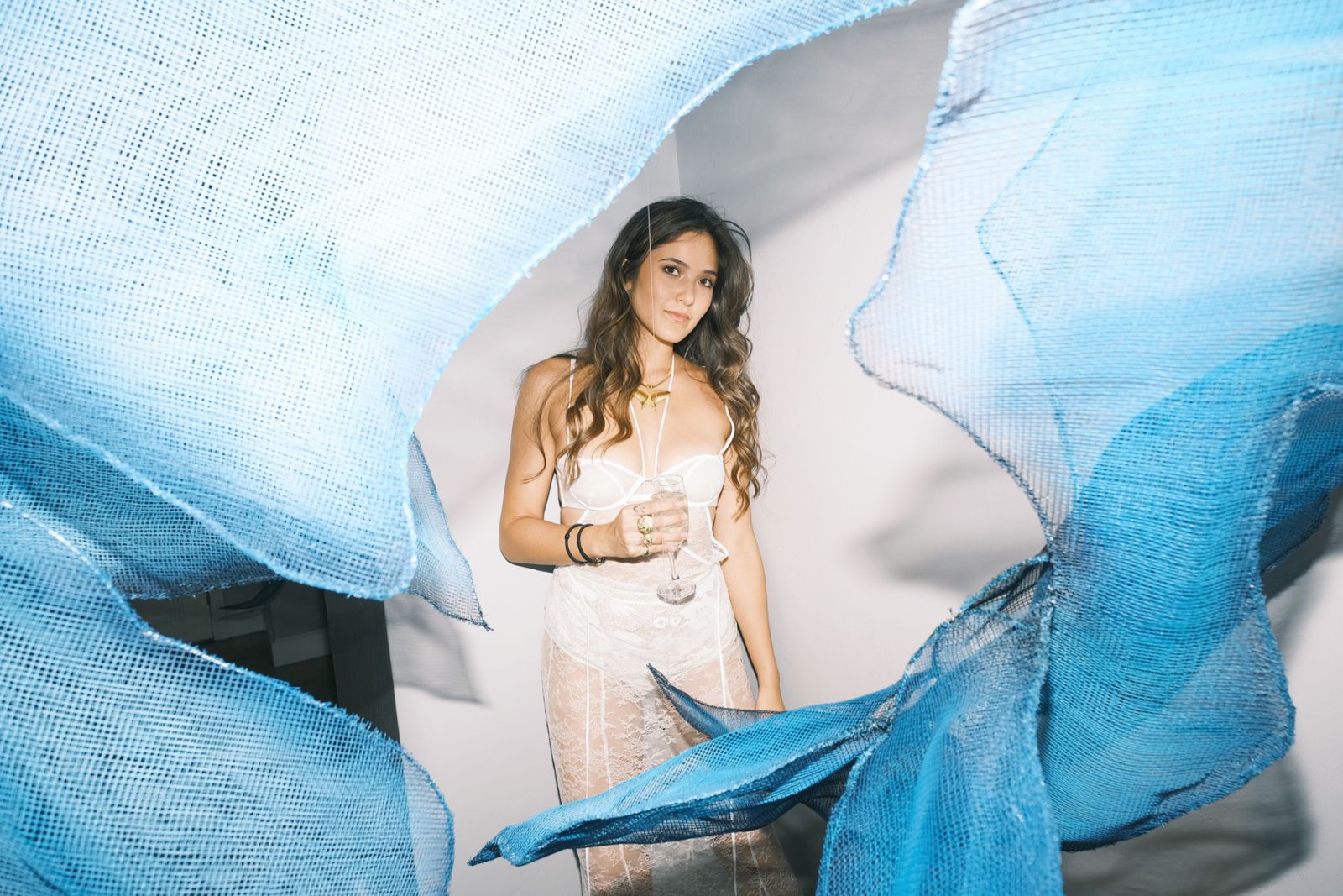 Kifu Augousti ready for cocktail hour, posing by a hand-dyed, metal mesh butterfly installation by Coard