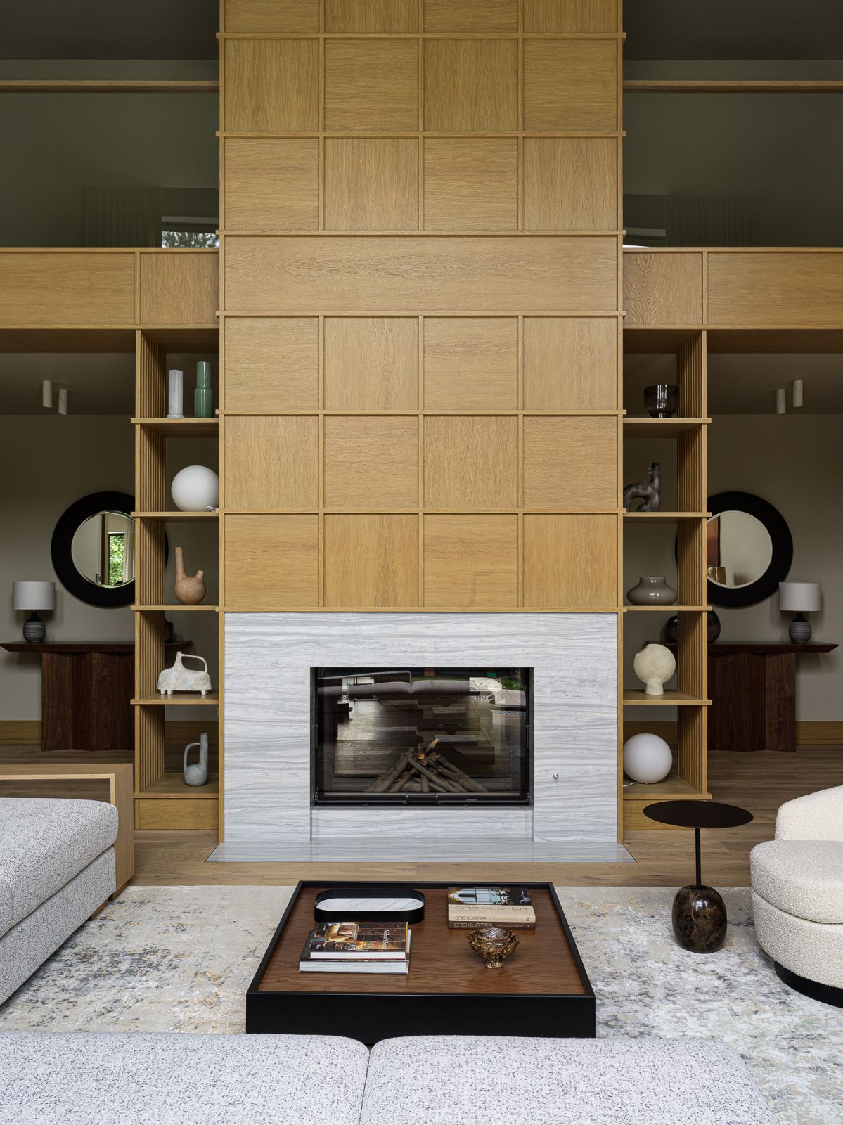 The double-sided fireplace clad in honey-coloured wood panels