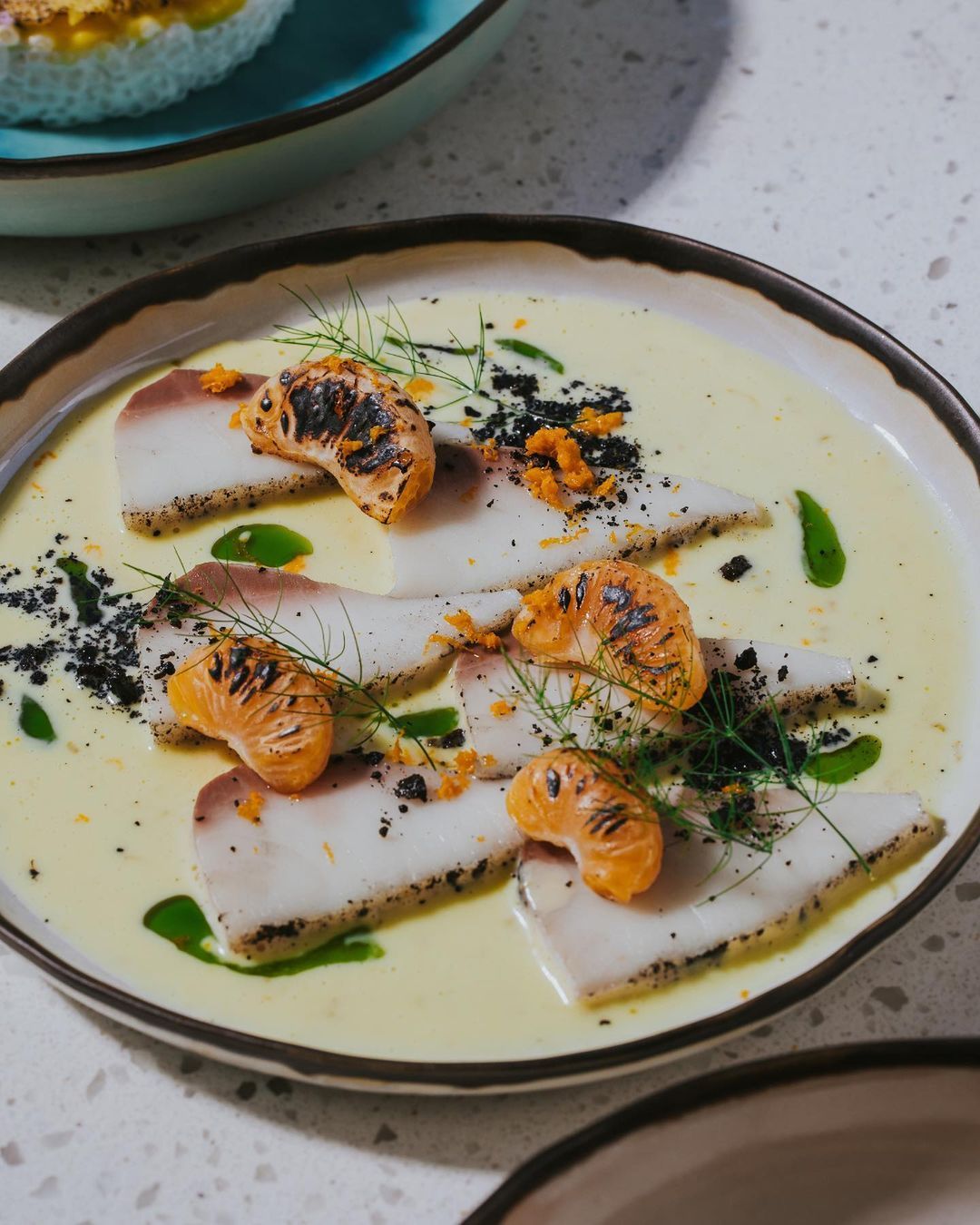 Sliced fish topped with mandarin orange segments (Photo: Instagram / @emberbeachclub)