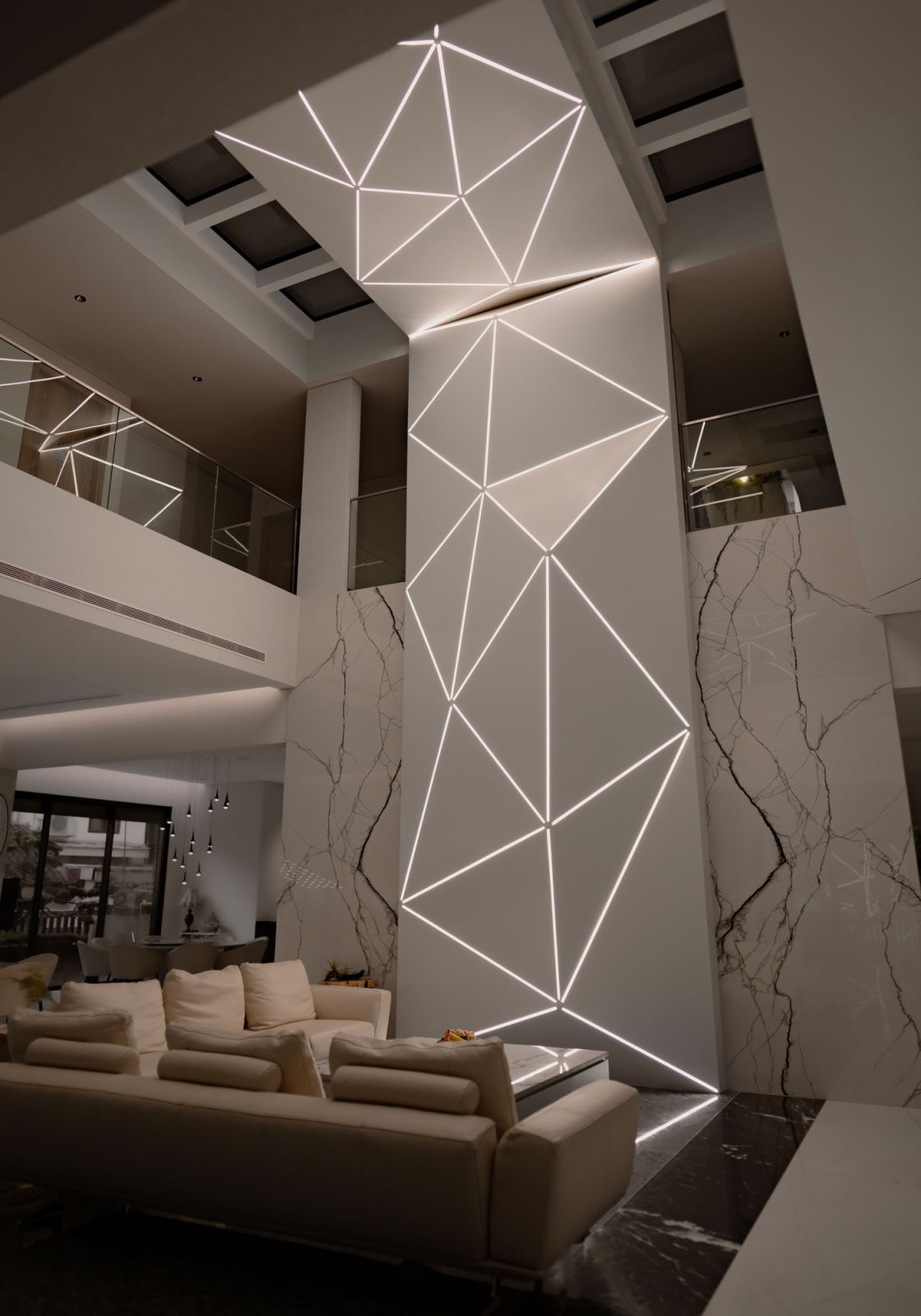An eight-meter geometric feature wall anchors the living area against a backdrop of rare blue marble