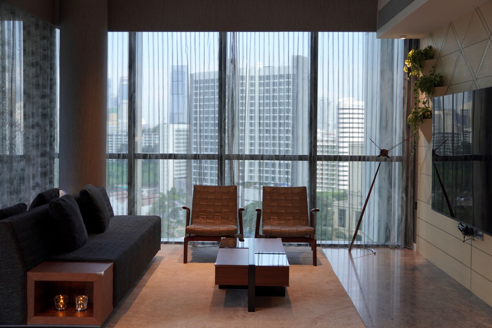 A living room featuring ripple fold sheer curtains from Coesa, with abstract designer fabric and thermal shaping