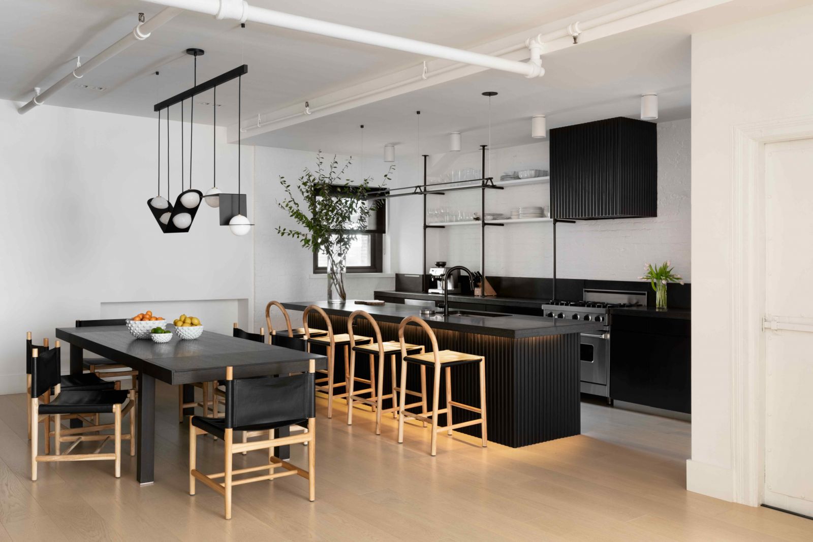 The dining-slash-kitchen area with a range hood and island with sleek, fluted detailing