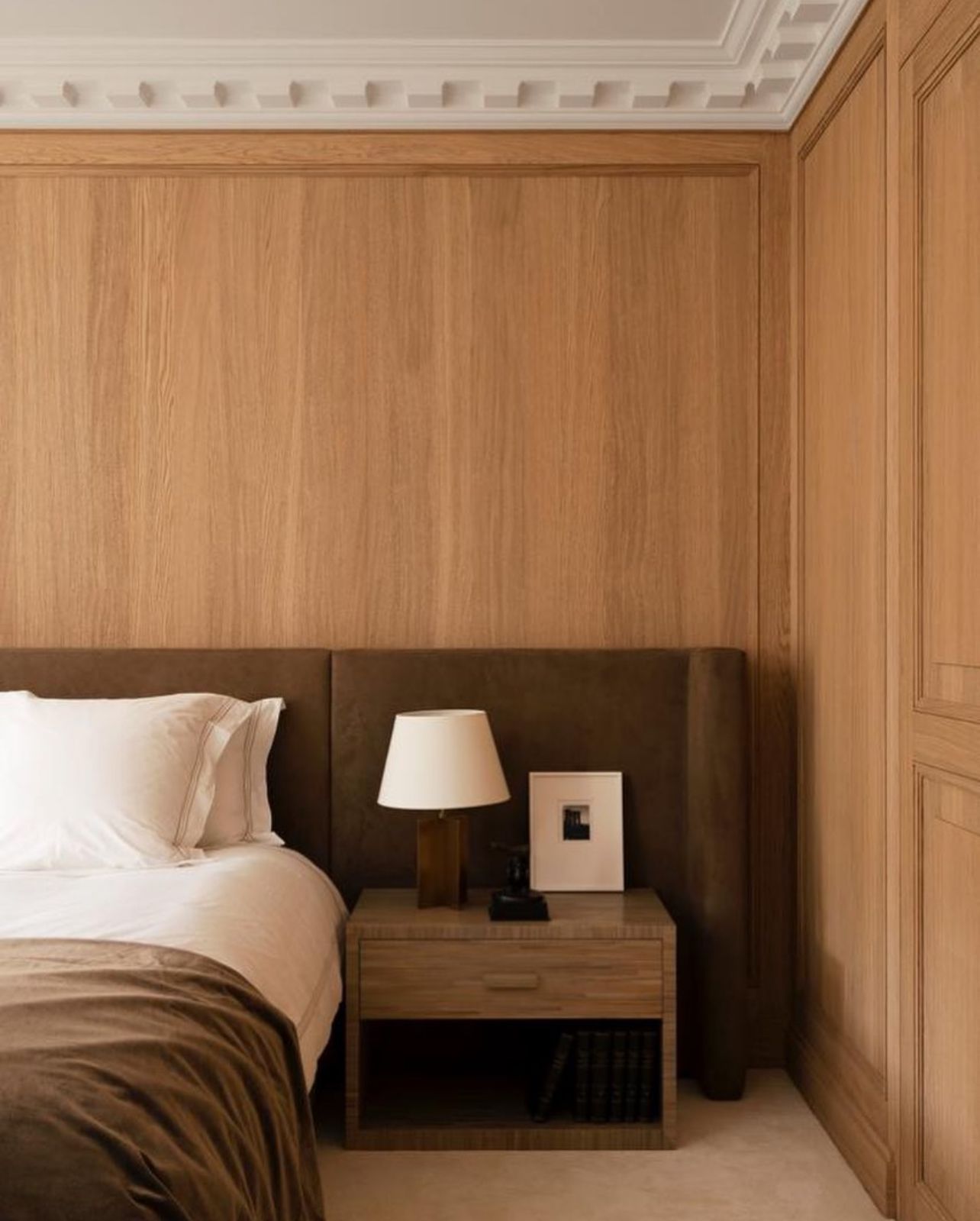 Oak woodwork, suede headboard, and marquetry table (Photo: Instagram / Charles Zana)