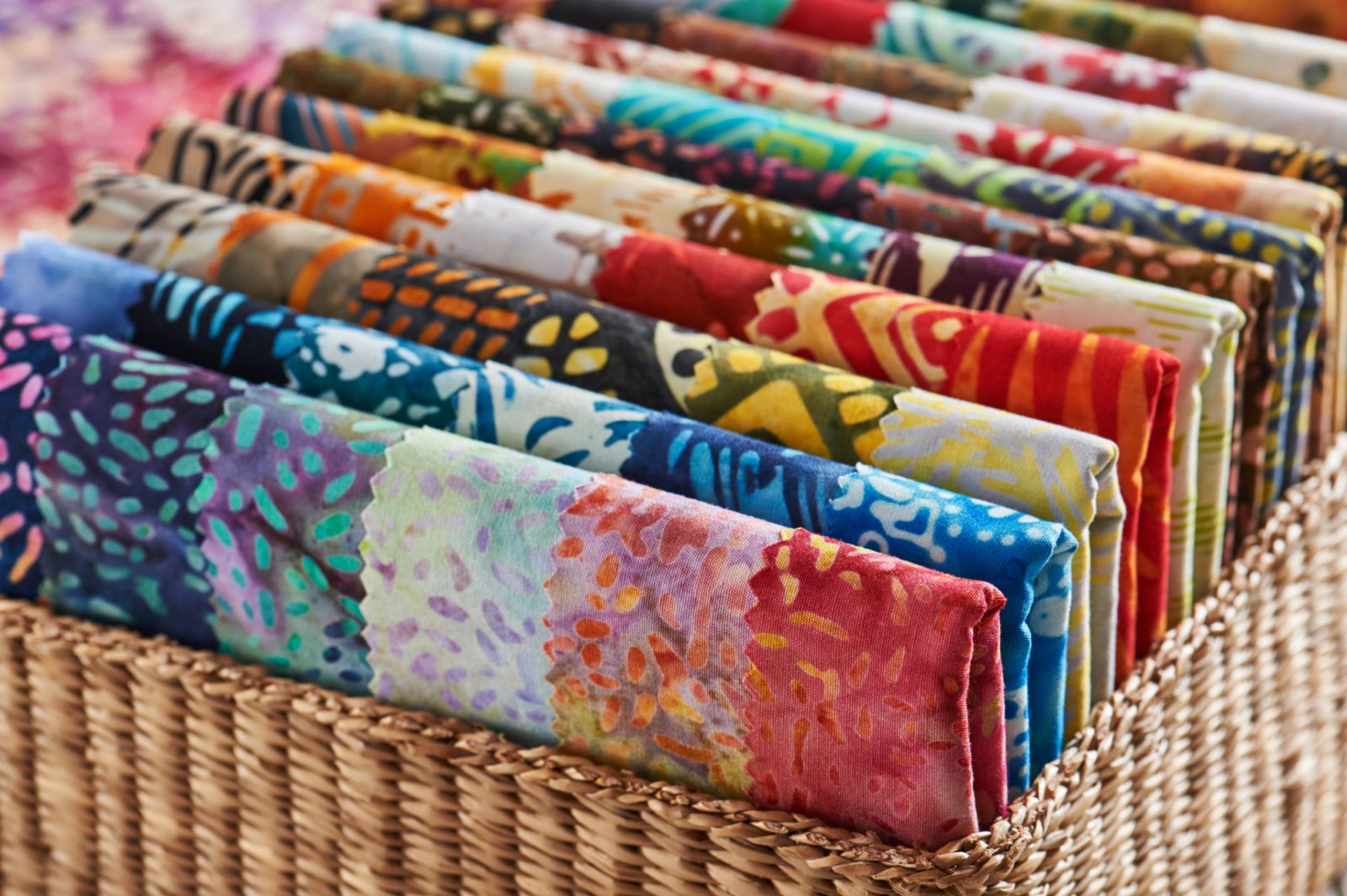 Folded bright pieces of quilting batik fabrics in a basket