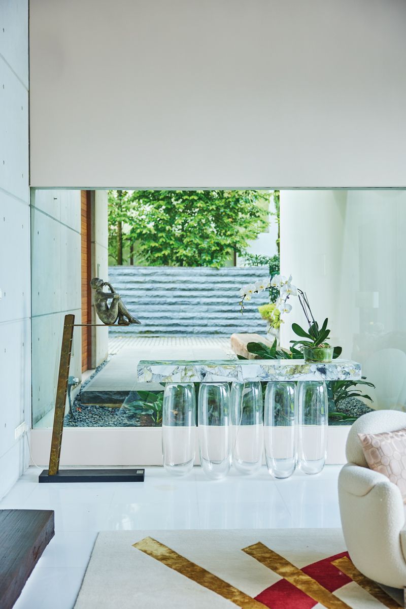 Inverted Gravity console and a sculpture by Aurora Canero serve as an artful foreground for the Good Class Bungalow's front window