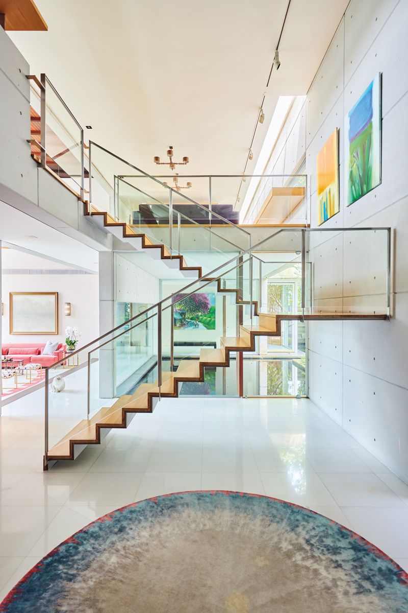 Glass balustrades allow onlookers to appreciate the architecture, furniture and paintings beyond the staircase