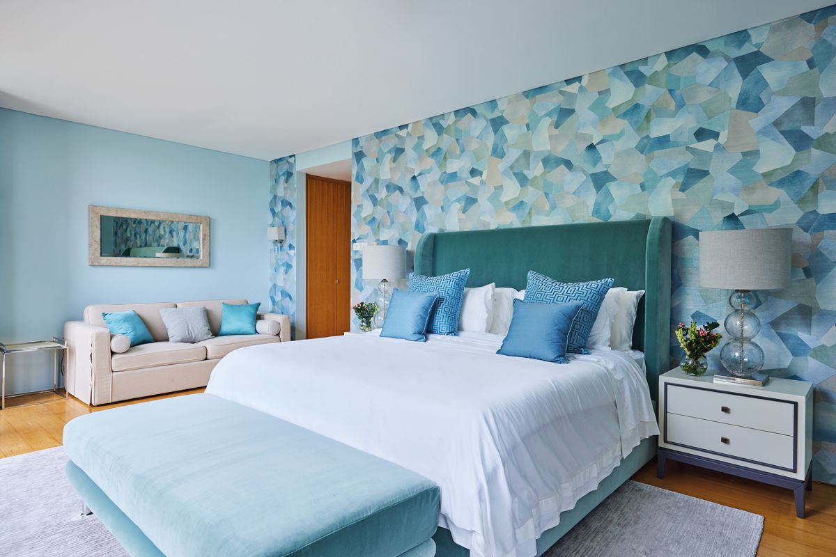 The pool-facing guest bedroom features an aquatic colour scheme anchored by the Kravet wallpaper