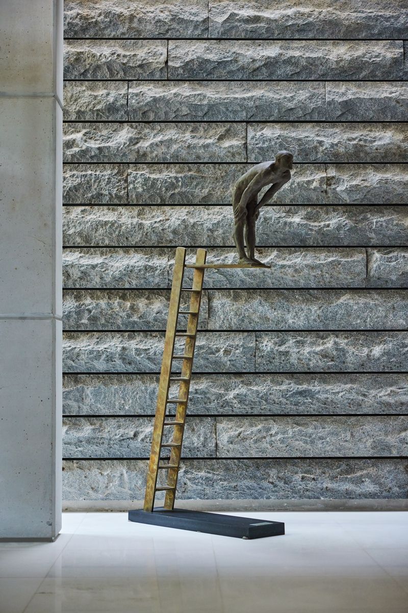 A bronze figure by Aurora Canero is strikingly set against a textured surface