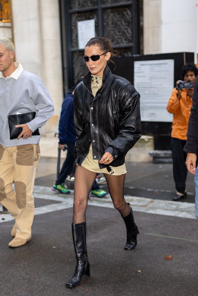 At Paris Fashion Week this month, Hadid opted for a minimalistic-meets-retro futuristic style with a high-neck minidress and accessorised with an eighties style leather jacket and motorcycle boots (Photo: Getty Images)