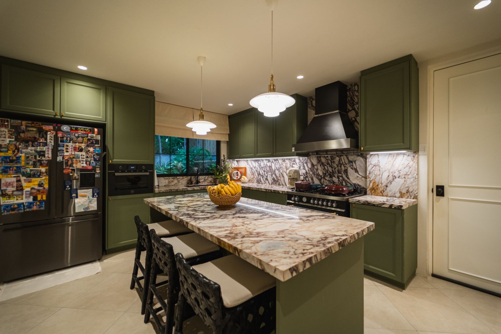 The kitchen, featuring Calacatta Viola marble countertops and green cabinets