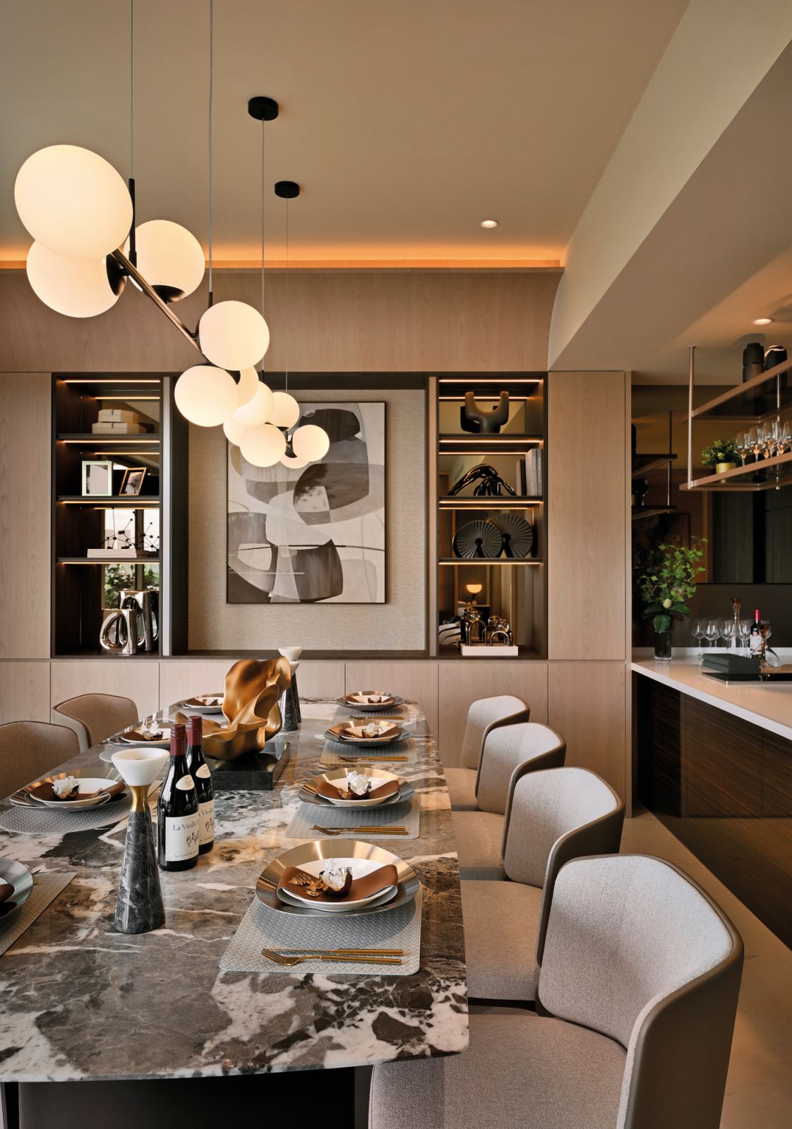 The penthouse’s glamorous dining room features a marble table top and display shelves with mirrored panels