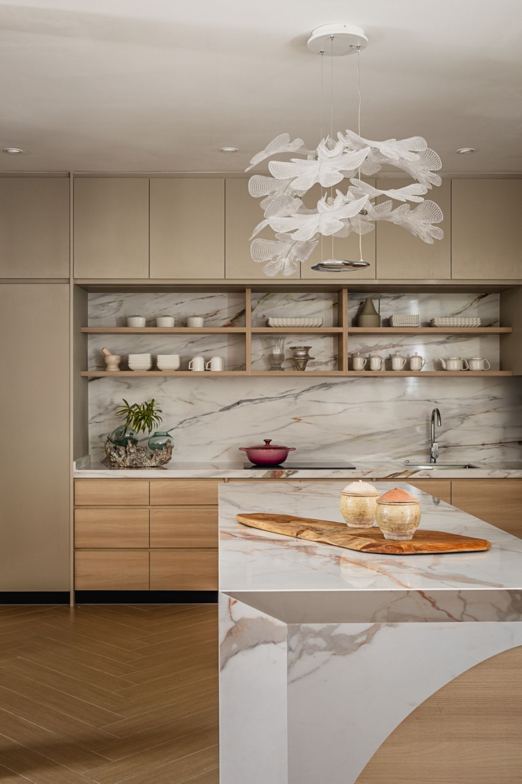 The kitchen has a luxurious feel with marble effect splashback and island