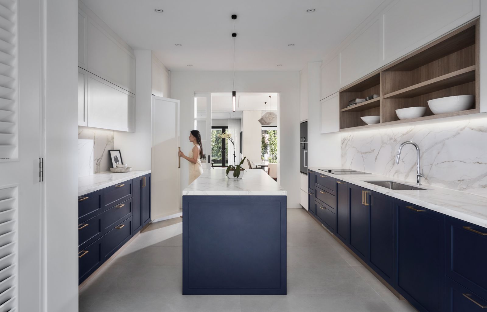The kitchen introduces a bold pop of colour with navy blue cabinetry