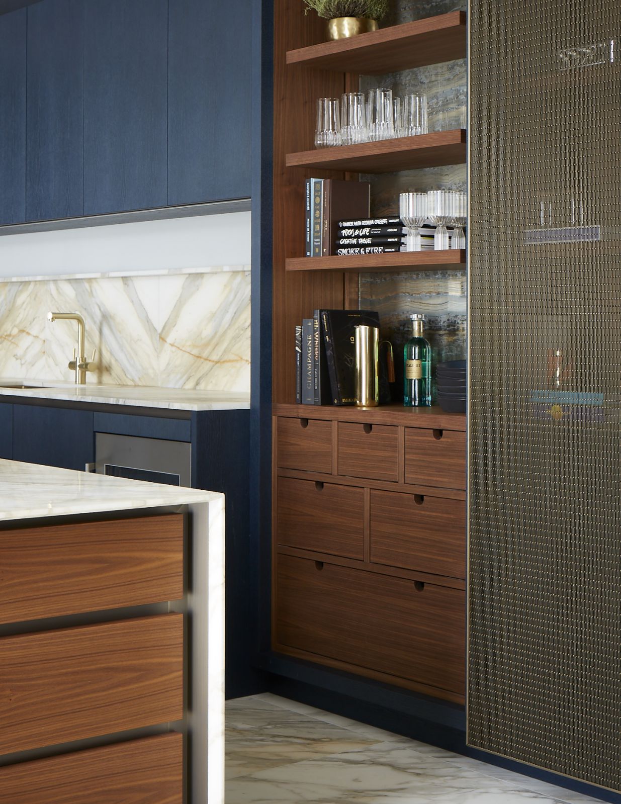 Honed marble, dark blue veneered cabinetry and antiqued brass details