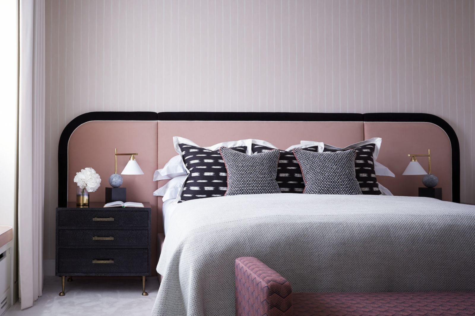 Bright pink walls and curved headboard reminiscent of the 1970s Palm Springs era