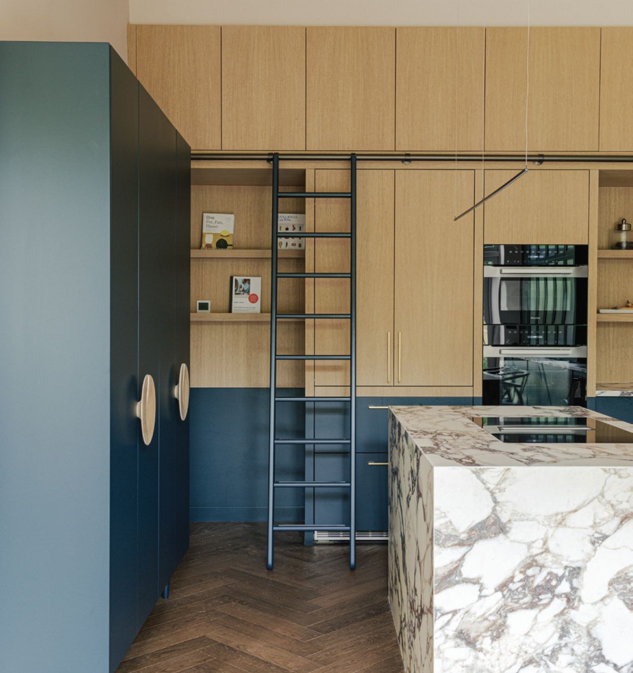 The kitchen area, with a marble countertop and sliding ladder