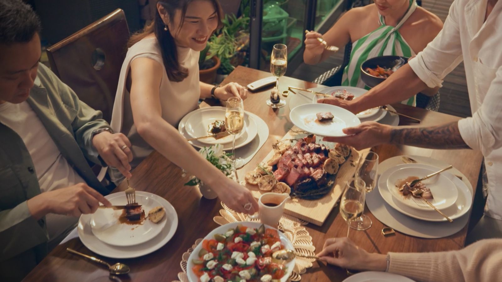 Homeowners Justin and Kelly’s guests enjoying the feast and creating memories in the home’s indoor-outdoor setting
