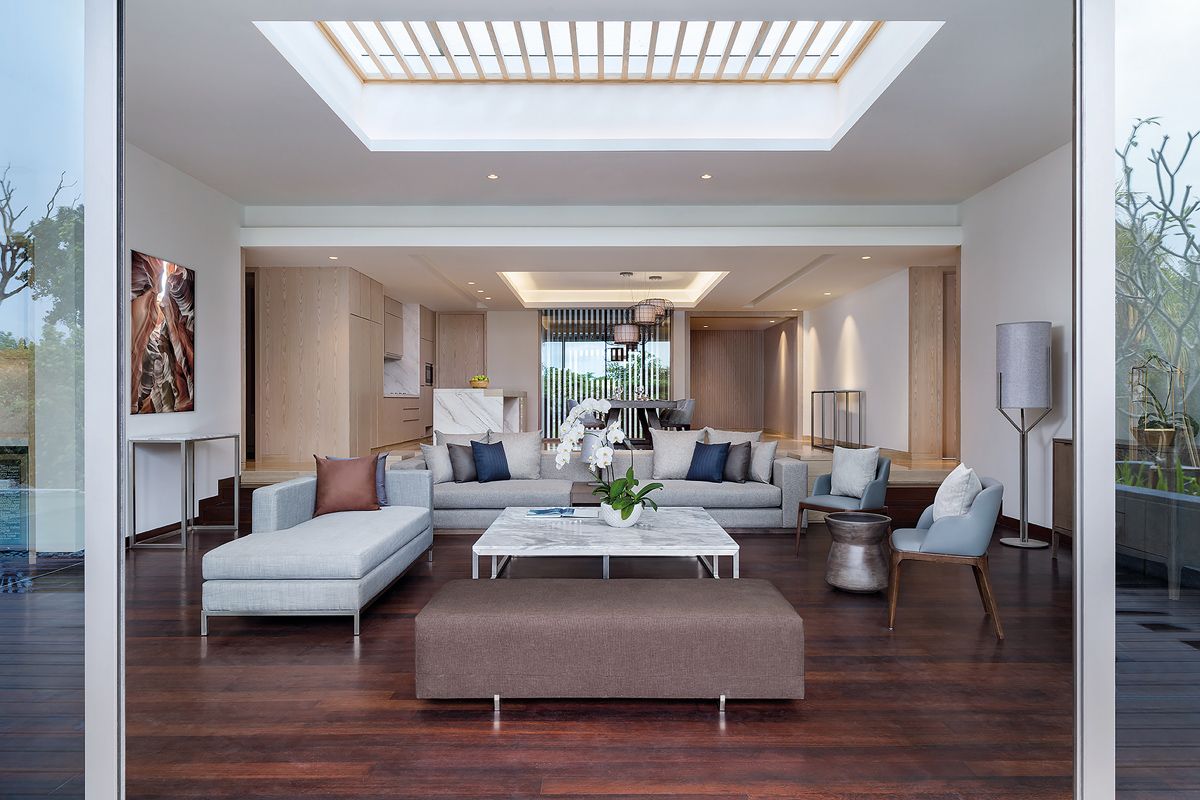 This villa features a sunken living room with plush furniture dressed in earth-tone hues