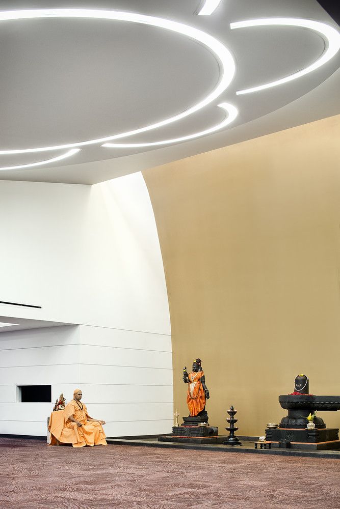A dramatically-sloped ceiling creates a golden aura around three deities indoors (Photo: Instagram / @miroriveraarch)