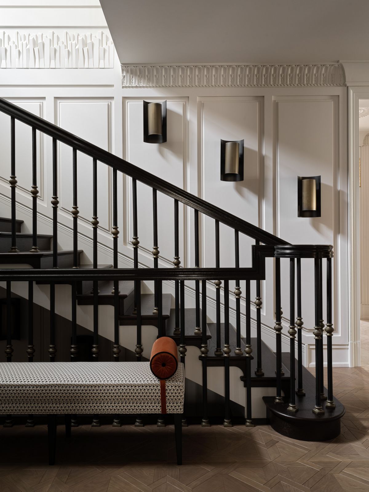 Details of the stairs leading up to the bedrooms, featuring distinctive cornices and custom-designed panels