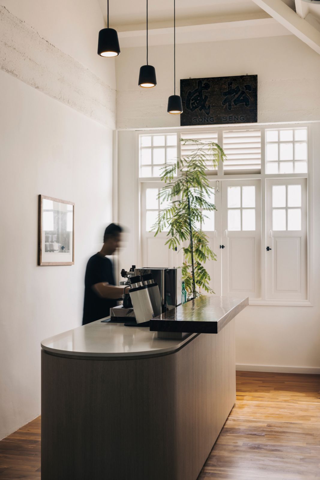 The coffee bar area blends old and new elements, like the signboard that exists harmoniously with the contemporary pendant lights