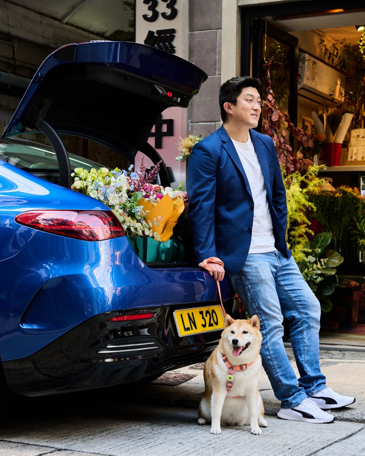 Wang and his pet Bailey stand at the back of Mercedes-Benz EQE outside of a flower shop (Photo: Zed Leets/Tatler Hong Kong)