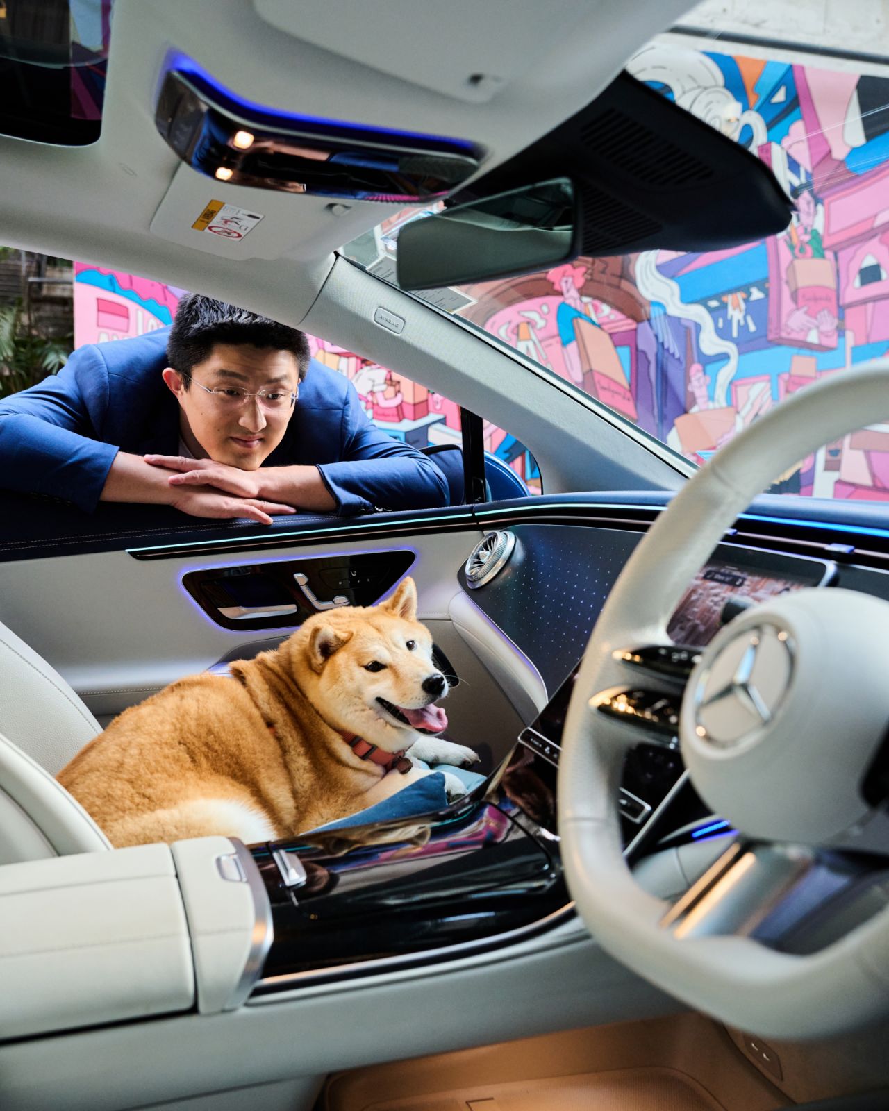 Wang looks at his pet Chiba Bailey, which is resting on a dog bed on one of the front seats in the car (Photo: Zed Leets/Tatler Hong Kong)
